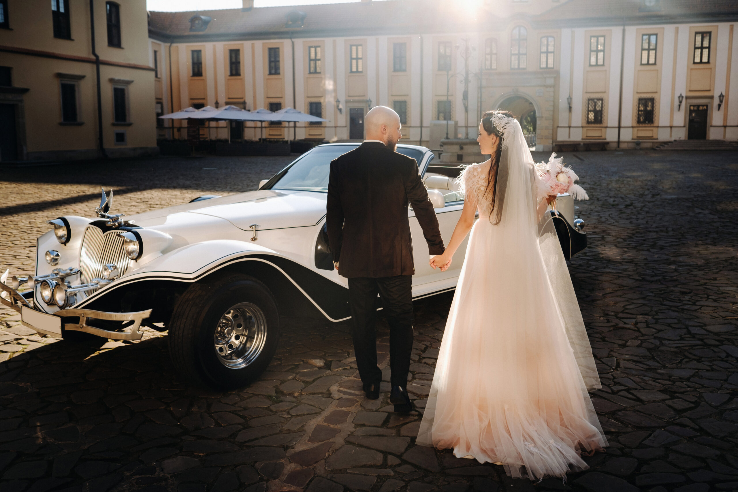 Brautpaar und Oldtimer vor einem Schloss, Hochzeitsplanung Deutschland, Lunaris Event Planning