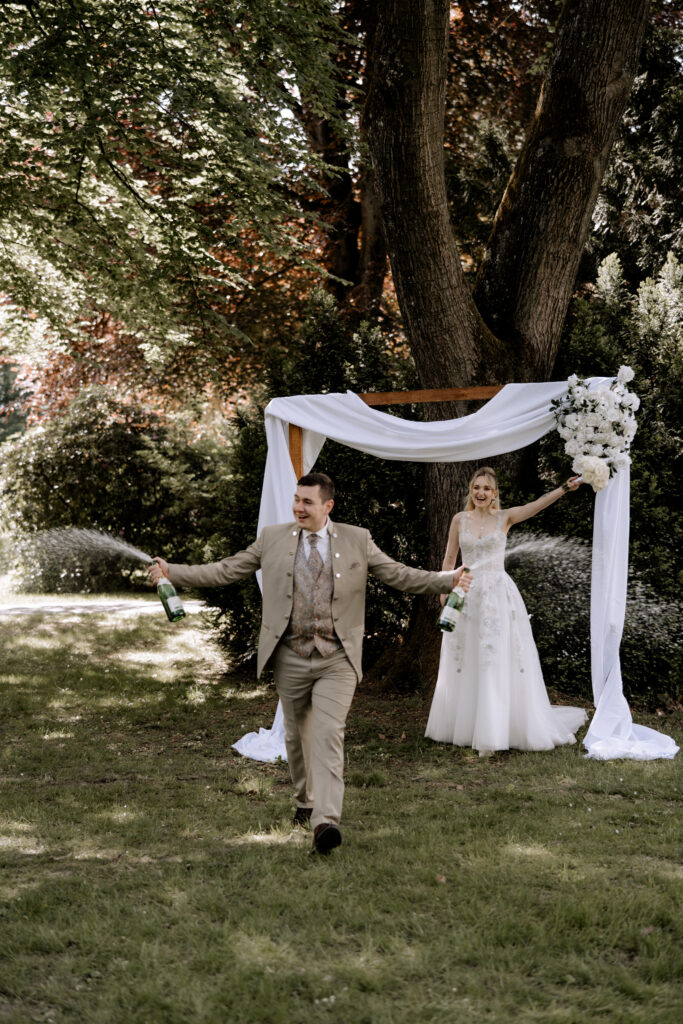 Brautpaar mit Champagner am Hochzeitstag, Hochzeitsparty mit Lunaris Event Planning, Hochzeitsplanung Deutschland