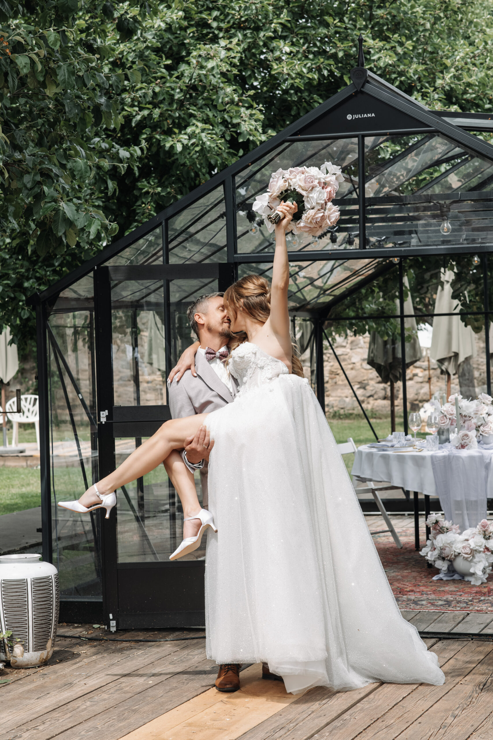 Brautpaar am Hochzeitstag mit Brautstrauß in der Hochzeitslocation vor dem Table Setting mit Hochzeitsdeko, Hochzeitsplanung mit Hochzeitsplanerin by Lunaris Event Planning